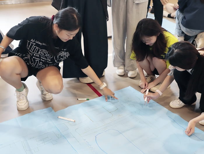 girls drawing a map of the campus