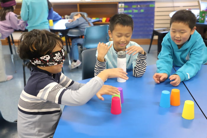 stacking cups into a pyramid while blindfolded